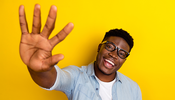 Smiling man holding up five fingers