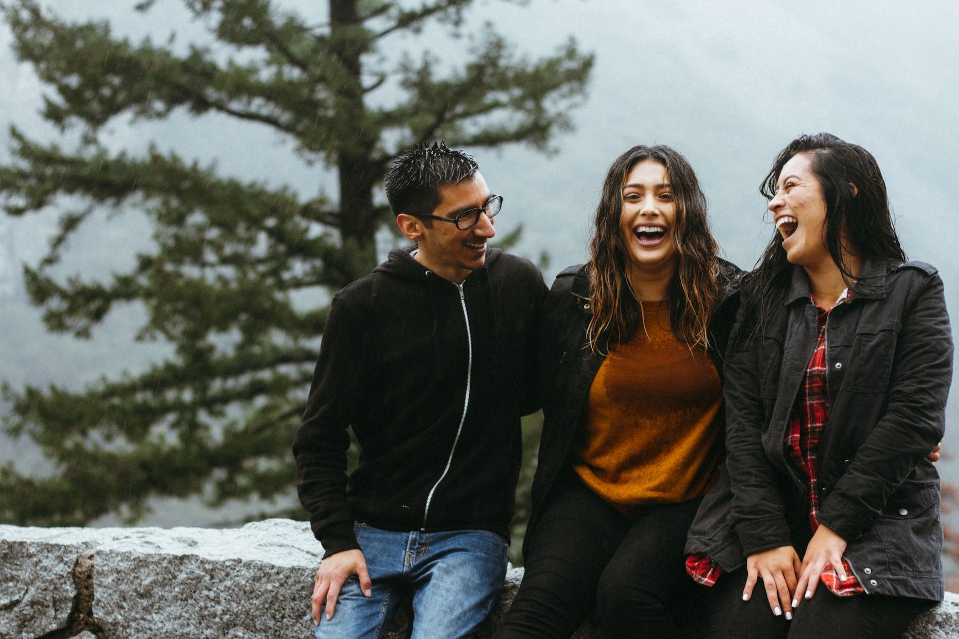 Three people outside laughing together
